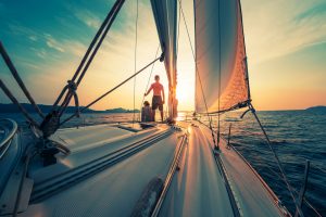 Young,Couple,Sailing,On,The,Boat,At,Sunset